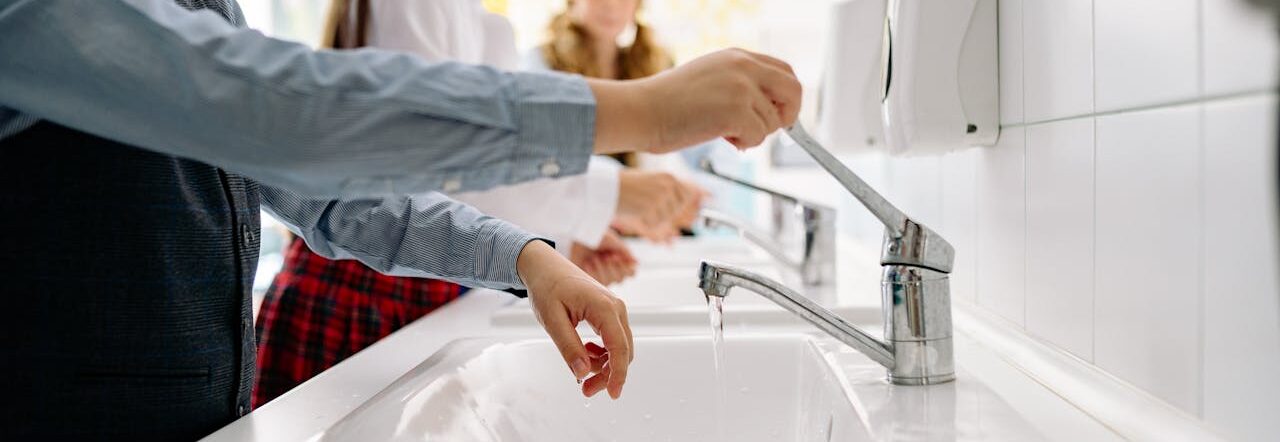 Kids washing hands at school sink promoting hygiene and health in educational setting.